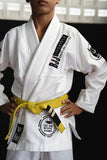 Child wearing the Kids White BJJ Gi Training Armor with black Bjjlifestyle logo patches and reinforced stitching.